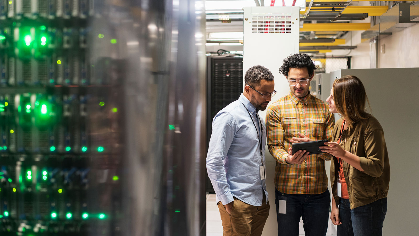 trois personnes qui regardent une tablette